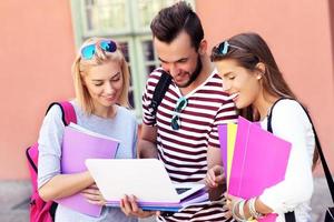 Group of happy students studying outdoors photo