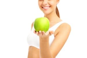 Fit woman giving green apple photo