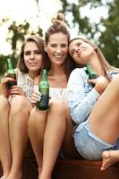 Happy group of friends drinking beer outdoors photo