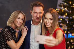 Business friends celebrating christmas party taking selfie photo