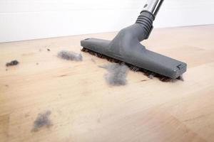 Dusty floor and vacuum cleaner close-up photo