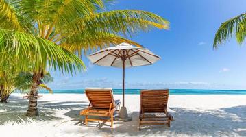 Tranquil beach scene. Panoramic tropical beach landscape for background or wallpaper, two lounge chairs with umbrella. Design of summer vacation holiday concept photo