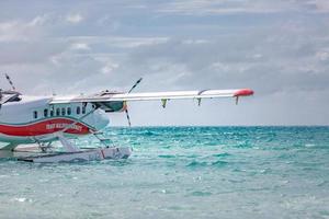 05.08.2018, Ari atoll, Maldives - Exotic scene with seaplane on Maldives sea landing. Vacation or holiday in Maldives concept background. Luxury travel - tourism and transportation template photo