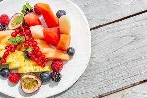 ensalada de frutas, fondo de madera simple y frutas frescas. foto