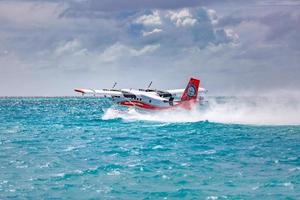 05.08.2018, Ari atoll, Maldives - Exotic scene with seaplane on Maldives sea landing. Vacation or holiday in Maldives concept background. Luxury travel - tourism and transportation template photo