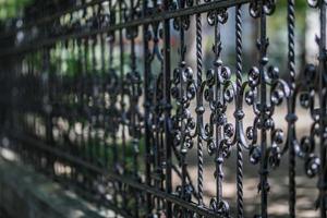 Steel fence, fragment of forged metal products with blurred nature background photo