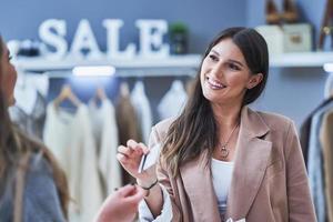 Woman seller and buyer in clothes store photo