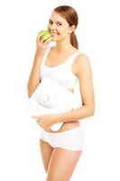 Fit woman with apple and bathroom scales photo