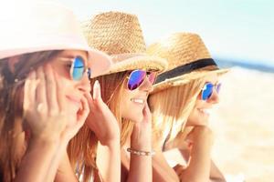 Group of friends sunbathing on the beach photo