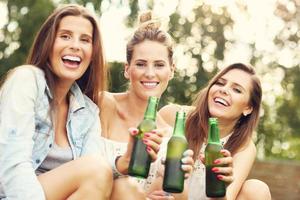 Happy group of friends drinking beer outdoors photo