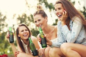 Happy group of friends drinking beer outdoors photo