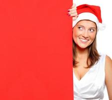 mujer con sombrero de santa sosteniendo un tablero en blanco foto