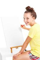 Young girl painting on an easel photo