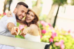 pareja en el parque apuntando a la cámara foto