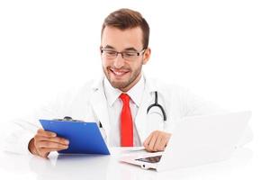 Doctor with laptop and documents photo