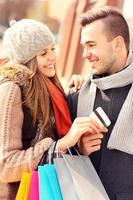 Young couple with credit card shopping in the city photo