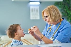 Pediatrician doctor examining little kids in clinic photo