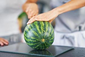 Nice adult woman with watermelon in the kitchen photo