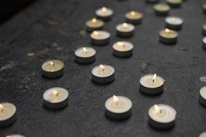 Lots of round candles on grave. Details of memorial ceremony. Candles made of wax.