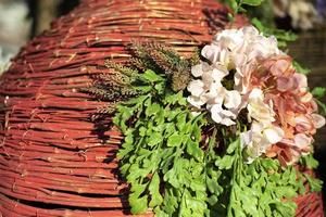 Beautiful background of twigs. Woven basket with flower. Street installation in spring. photo