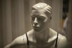 Mannequin face. White figure made of plastic. Details of showcase of clothing salon. photo