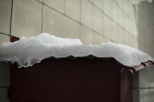 Ice on roof. Snow on building. Icy wall. Winter weather. photo