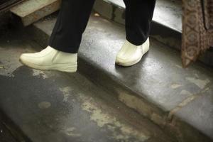 Feet go up steps. White shoes. Move up stairs. photo