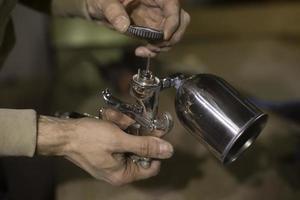 Guy checks paint sprayer. Paint sprayer in hand. photo