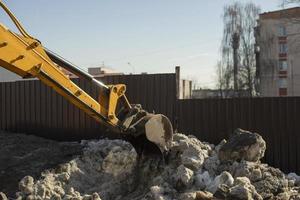 Snow removal on road. Ladle collects snow from chaus. Escalator cleans curbs. photo