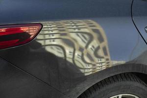 conducían el coche por detrás. reflexión en la superficie de la máquina. rueda y faro. foto