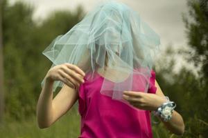 Girl in blue veil. Veil on head. Blue fabric on hair. Bridesmaid. photo