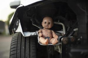 muñeca bebé en la rueda del coche. sintonizador muñeca dentro del mecanismo de la máquina. foto