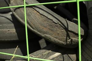 Old tires. Used wheels. Discarded rubber from car. Landfill details. photo