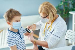 Pediatrician doctor examining little kids in clinic photo