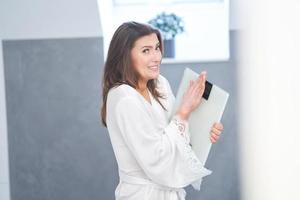 Young nice brunette woman in the bathroom with weight scale photo