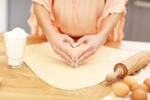 Young woman trying to cook something in kitchen photo