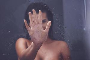 Adult woman under the shower in bathroom photo