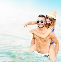 pareja feliz divirtiéndose en la playa foto