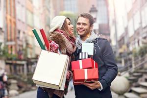 Happy couple shopping for Christmas in the city photo