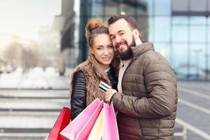 pareja joven de compras en la ciudad con tarjeta de crédito foto