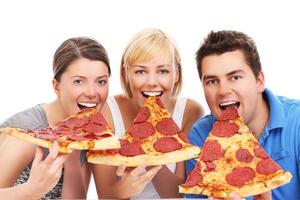 amigos comiendo enormes porciones de pizza foto