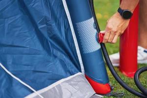 Una pareja joven y agradable divirtiéndose en acampar montando carpa foto