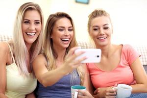 Three beautiful young women chilling at home photo