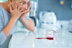 Young woman and spilled wine in the kitchen photo