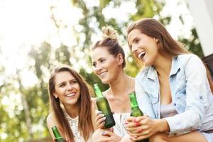 feliz grupo de amigos bebiendo cerveza al aire libre foto