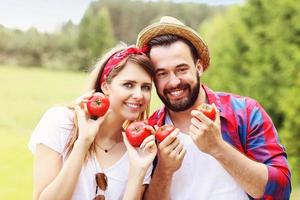 Young couple planting organic tomatoes photo