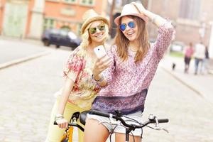 dos amigas felices montando en bicicleta tándem foto