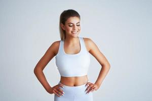 Adult beautiful woman working out over light background photo