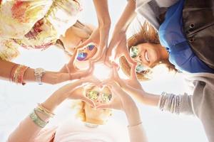 Group of happy friends showing hearts photo