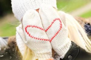 Woman covering her face with winter gloves photo